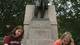 Tara Gerke, left, and Lauren Costin place the pennies underneath the statue.